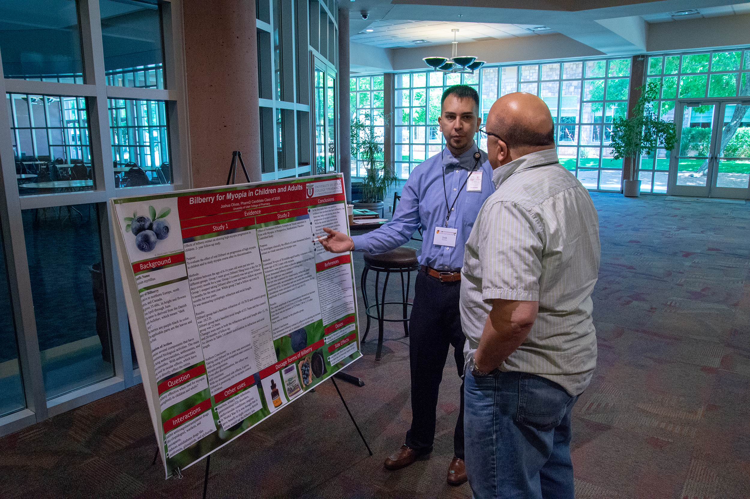 man presenting his poster to other man