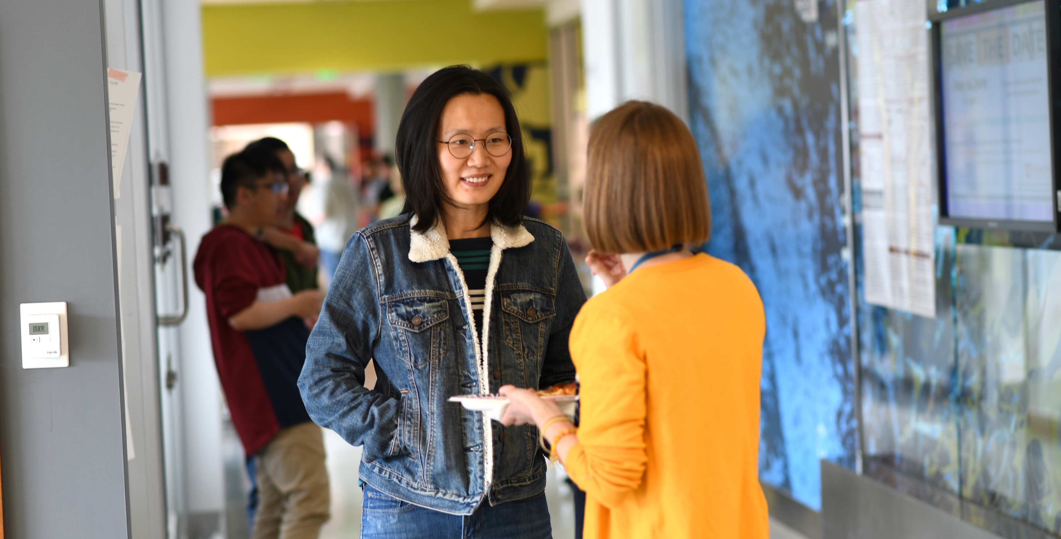 Two women talking in hallway