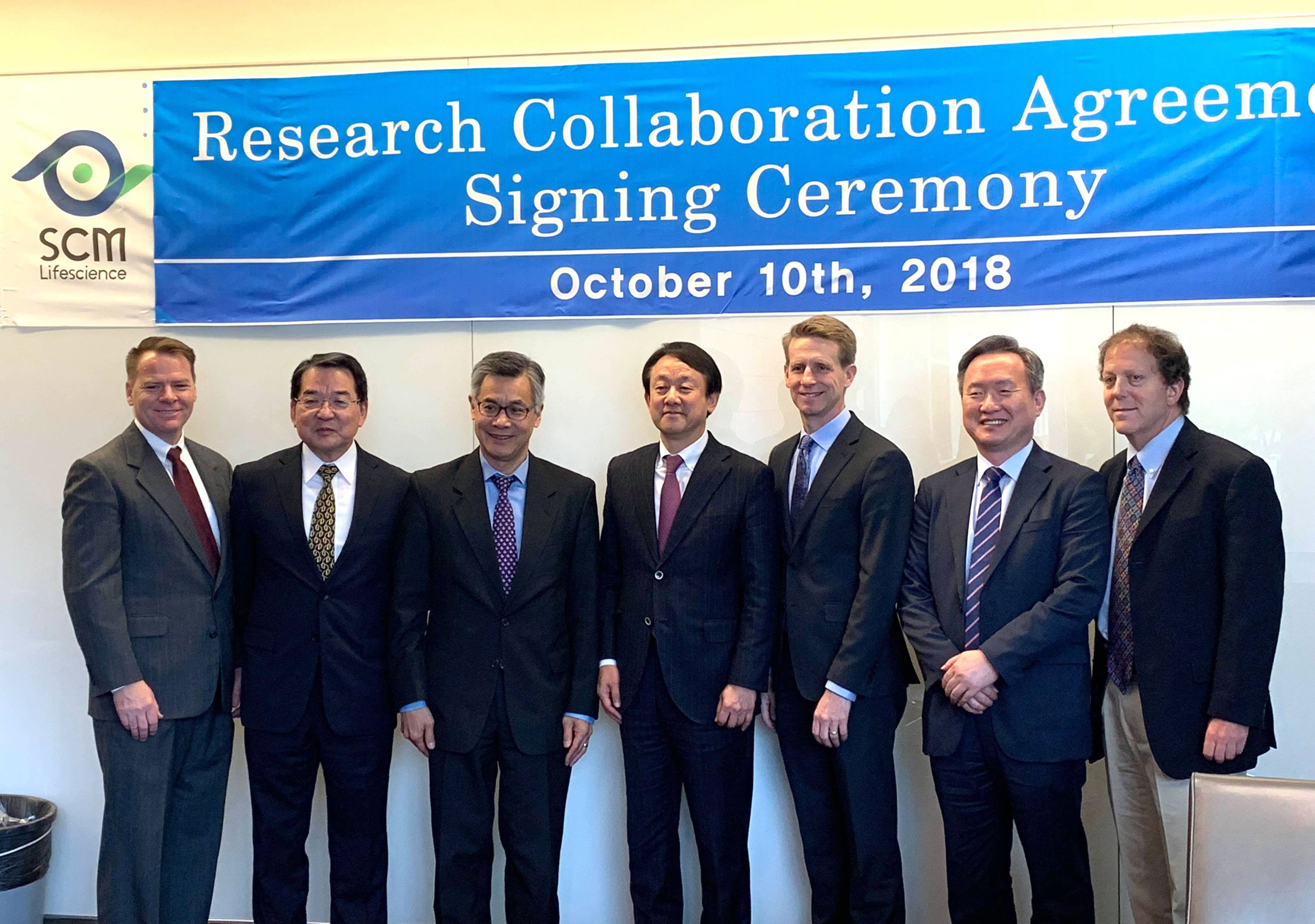 Research Collaboration Agreement Signing Ceremony 2018 group in front of sign