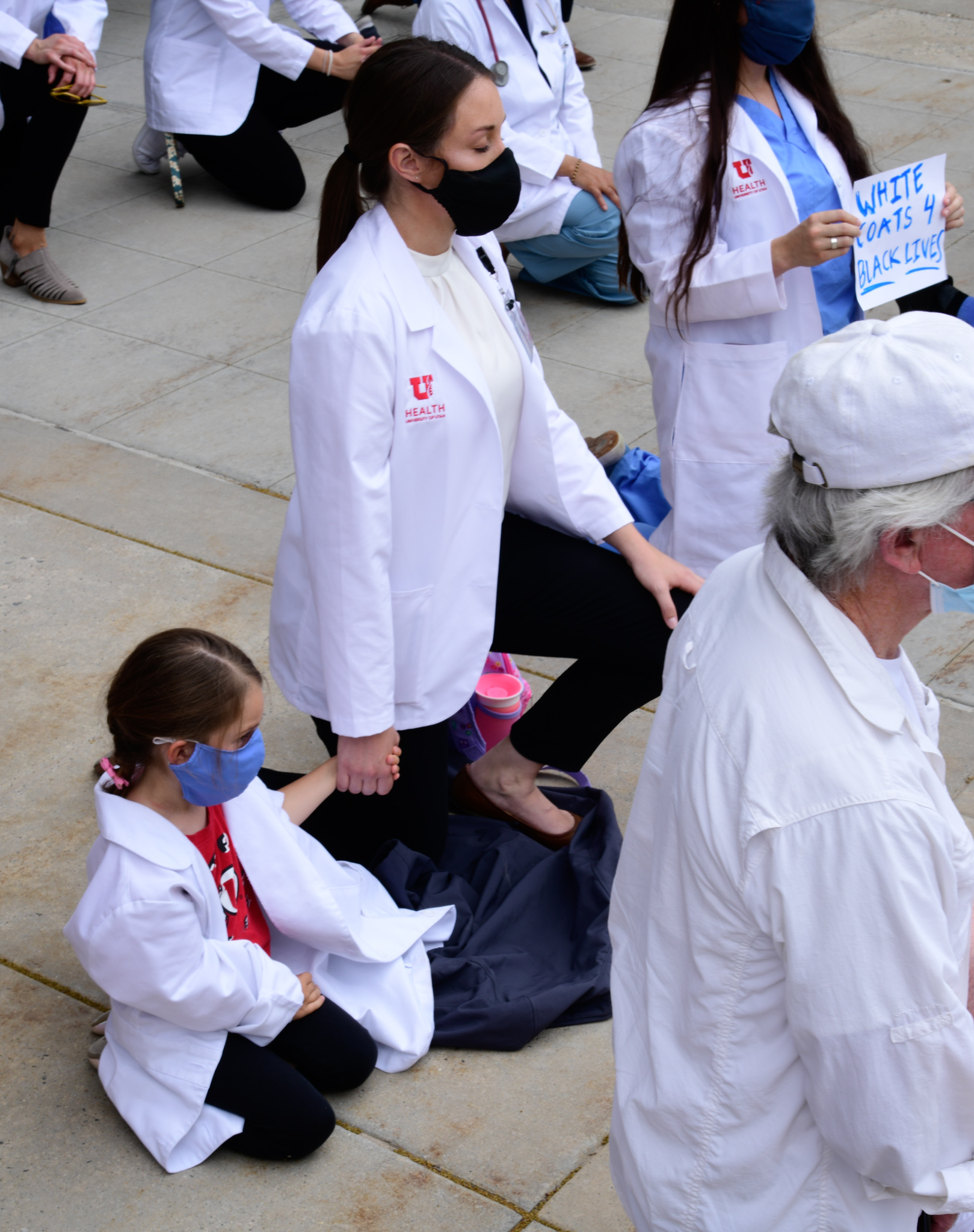 White Coats for Black Lives 3 Woman kneeling with child