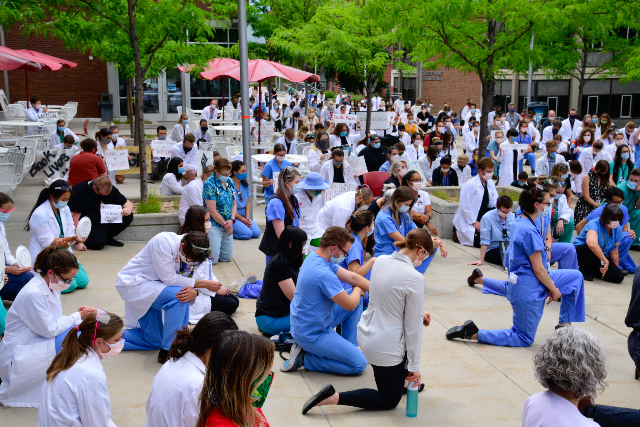 white coats for black lives group kneeling