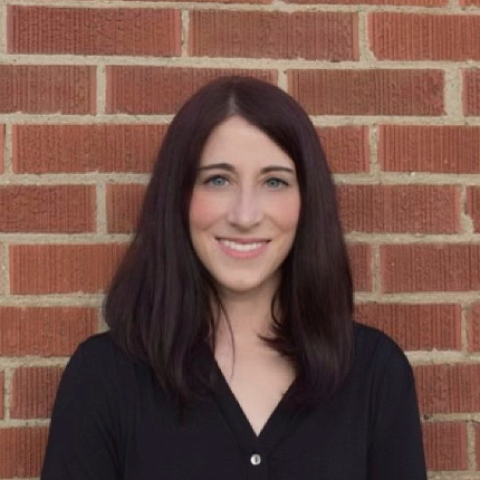 A woman pictured in front of a brick wall