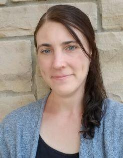 A woman pictured in front of a brick wall