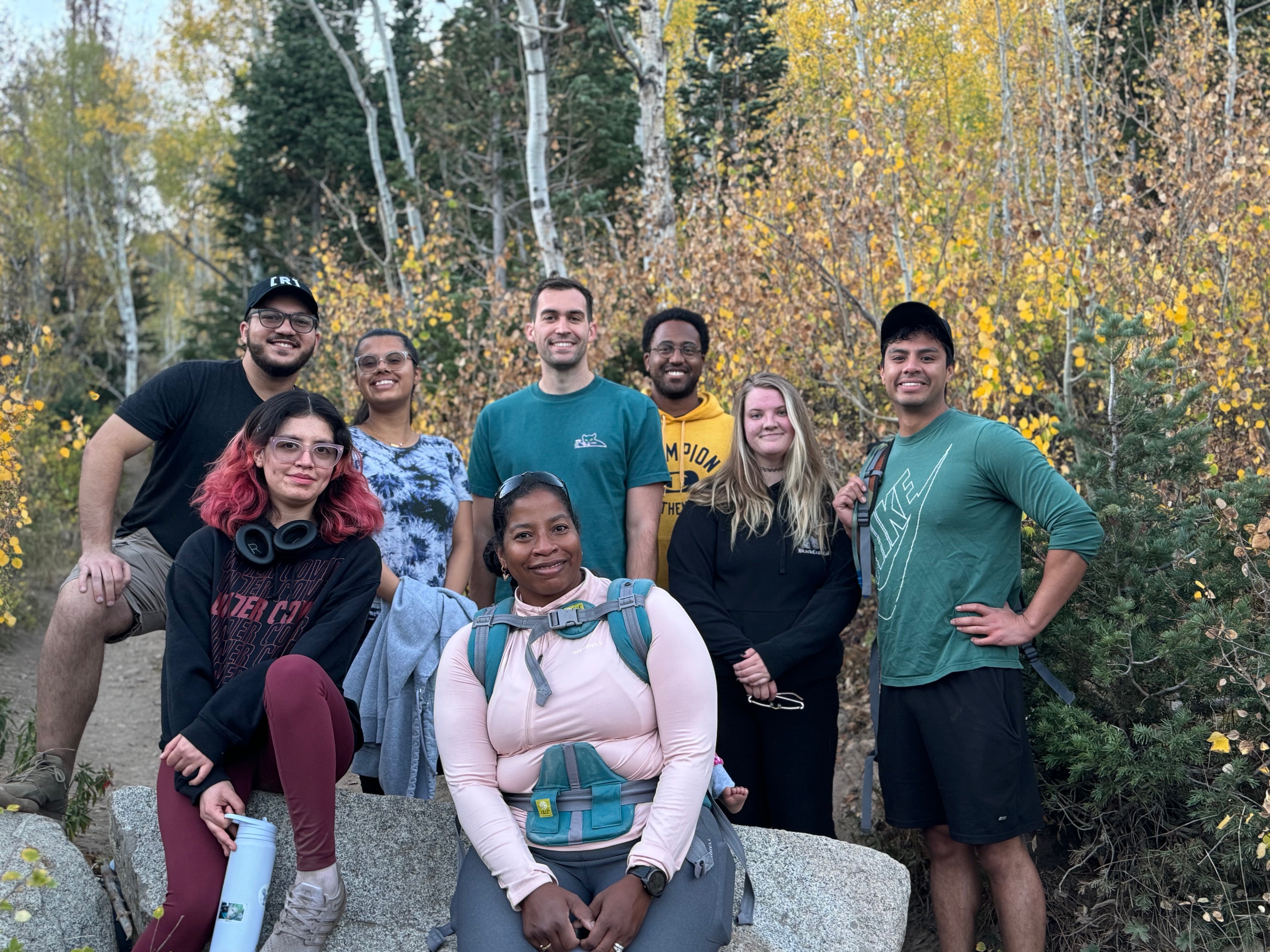 students in front of fall foliage