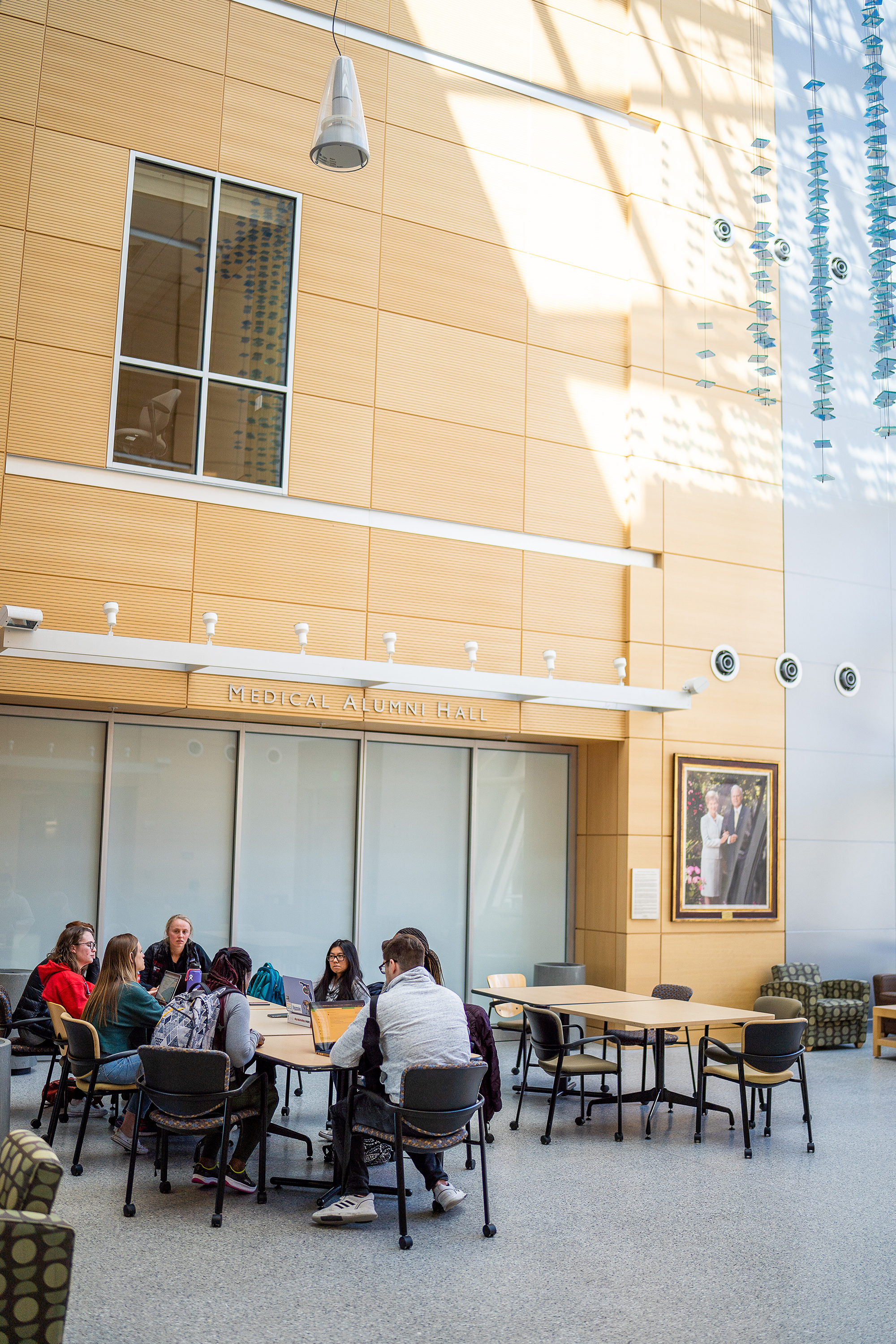 3 individuals sitting, talking in COP atrium