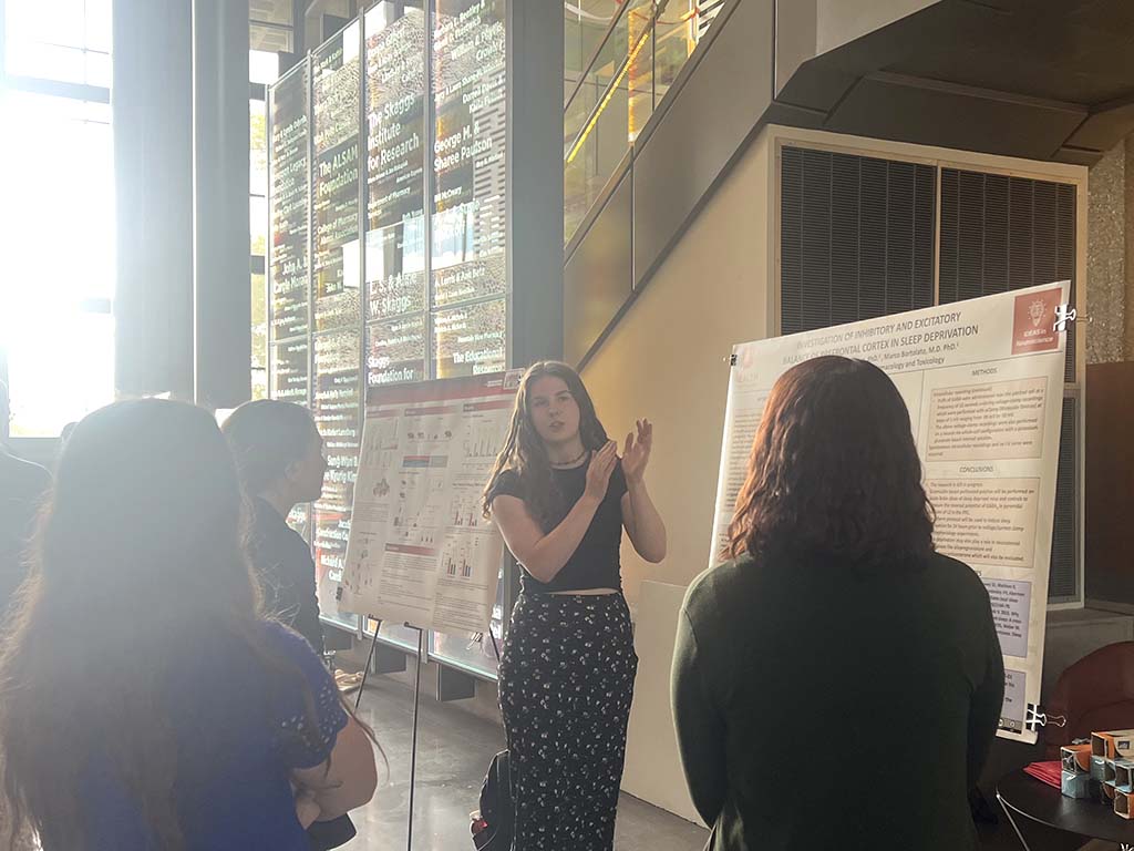 2 students in front of a poster, Skaggs Building