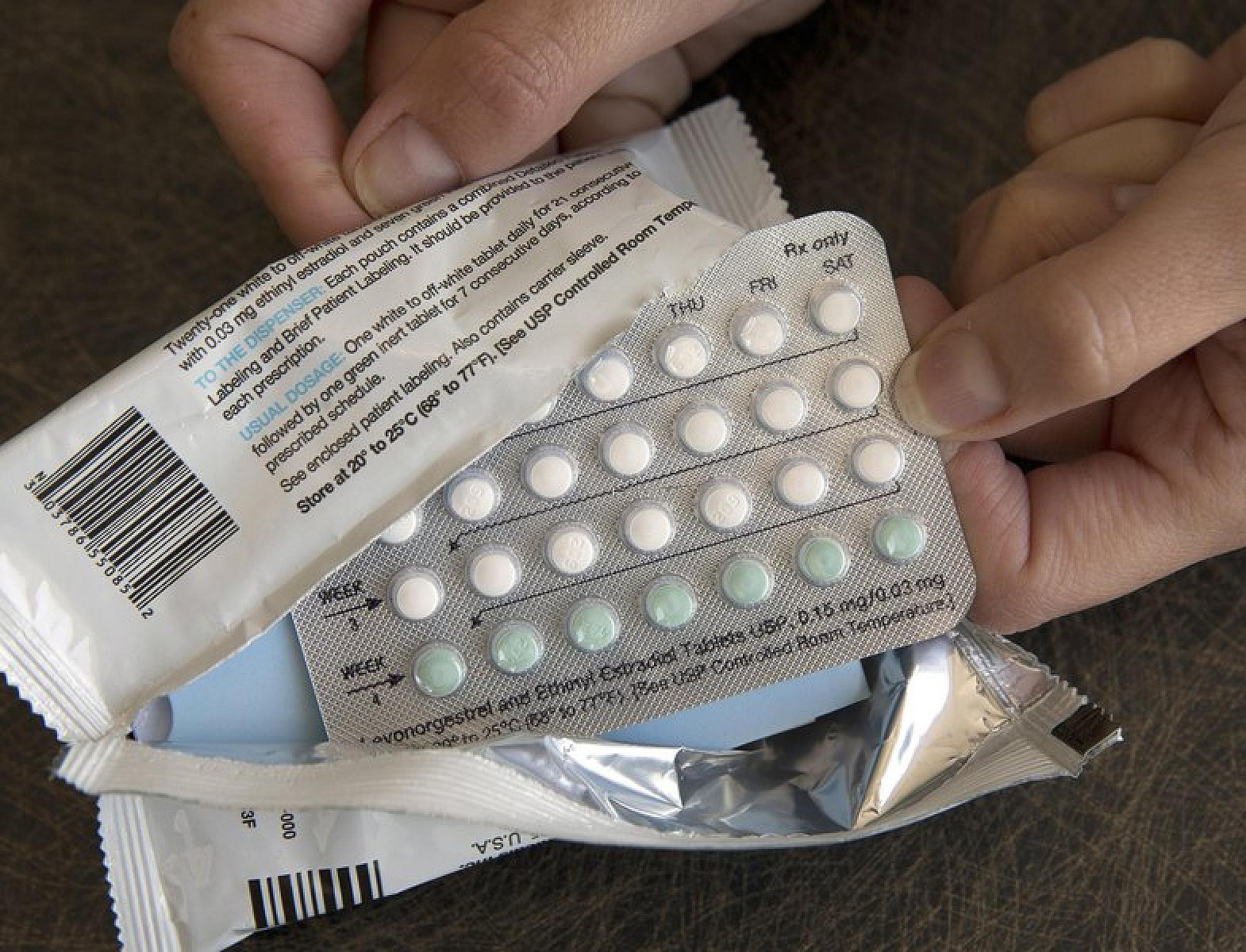 Stock person opening birth control pills