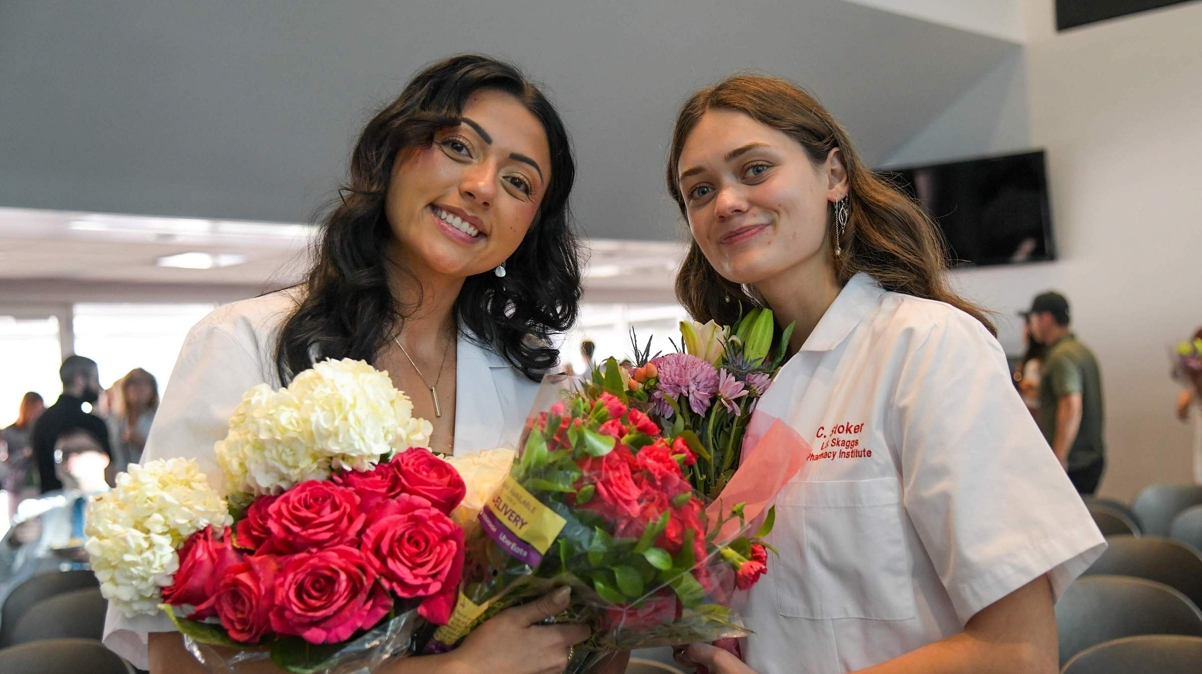 Students at College of Pharmacy 2024 White Coat Ceremony with Flowers